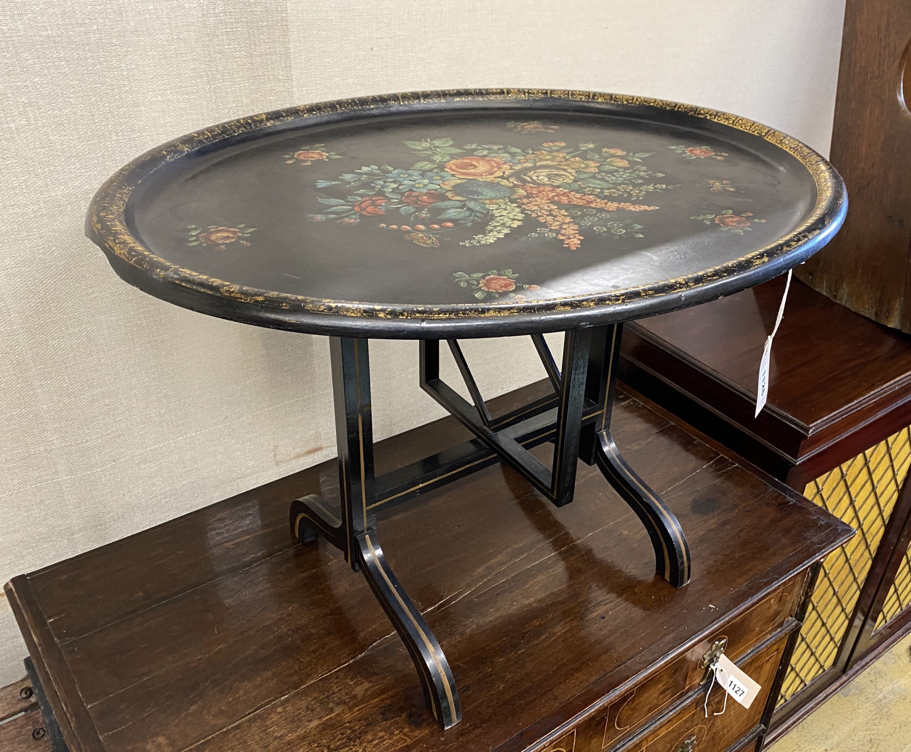 An oval papier mache folding occasional table, width 75cm, depth 60cm, height 52cm